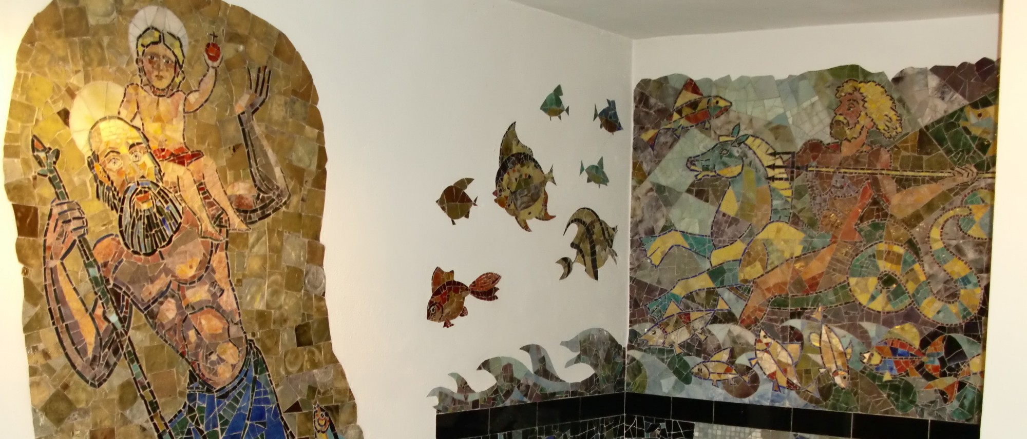 Das Foto zeigt das Bad in der Wohnung von Karl Schmidt mit bunten Mosaiken. Man sieht links den hl. Christopherus mit dem Christusknaben auf der Schulter, rechts den reitenden Meeresgott Poseidon mit Dreizack Fische jagend.