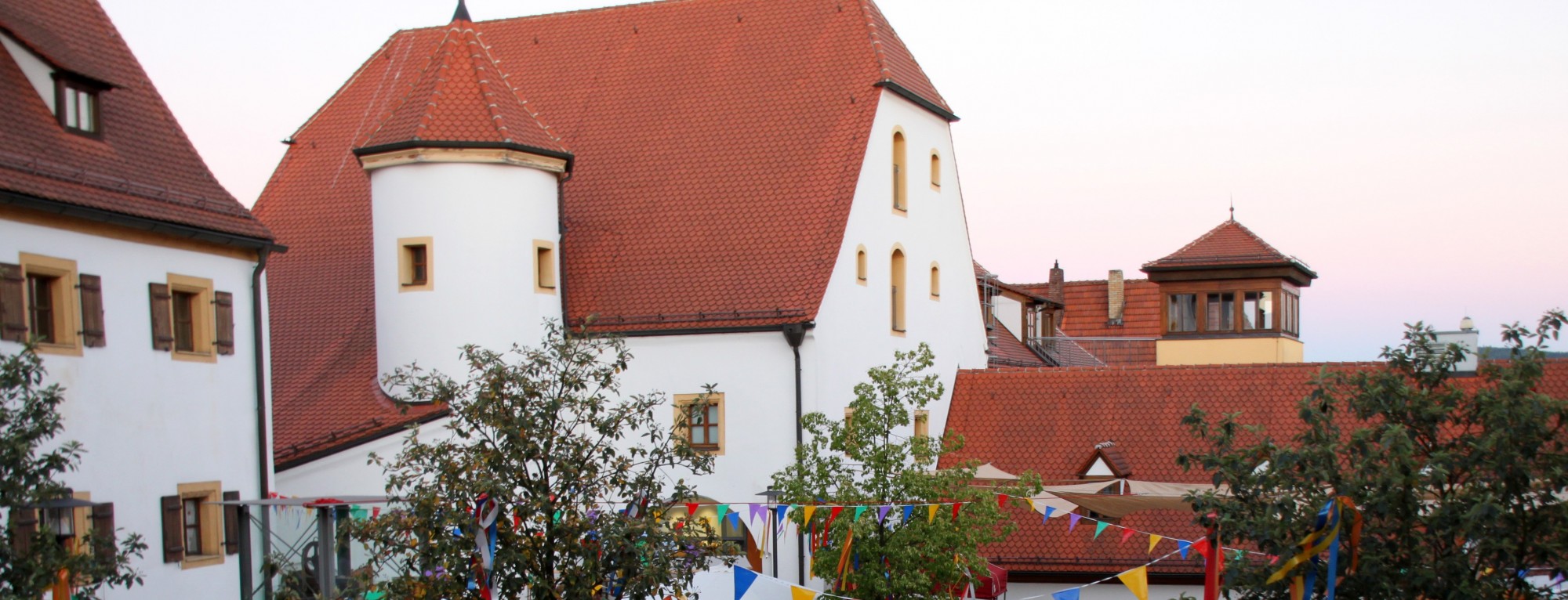 Das Foto zeigt den Spitalhof in Nabburg, mittig das Stadtmuseum Zehentstadel, links im Anschnitt dem Bürgerspital, rechts im Hintergrund den Alten Pfarrhof.