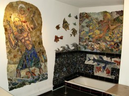 Das Foto zeigt das Bad in der Wohnung von Karl Schmidt mit bunten Mosaiken. Man sieht links den hl. Christopherus mit dem Christusknaben auf der Schulter, rechts den reitenden Meeresgott Poseidon mit Dreizack Fische jagend